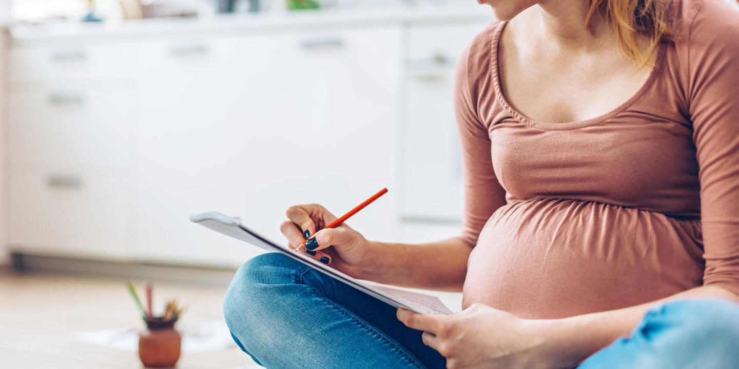 Pregnant woman drawing in a sketchbook